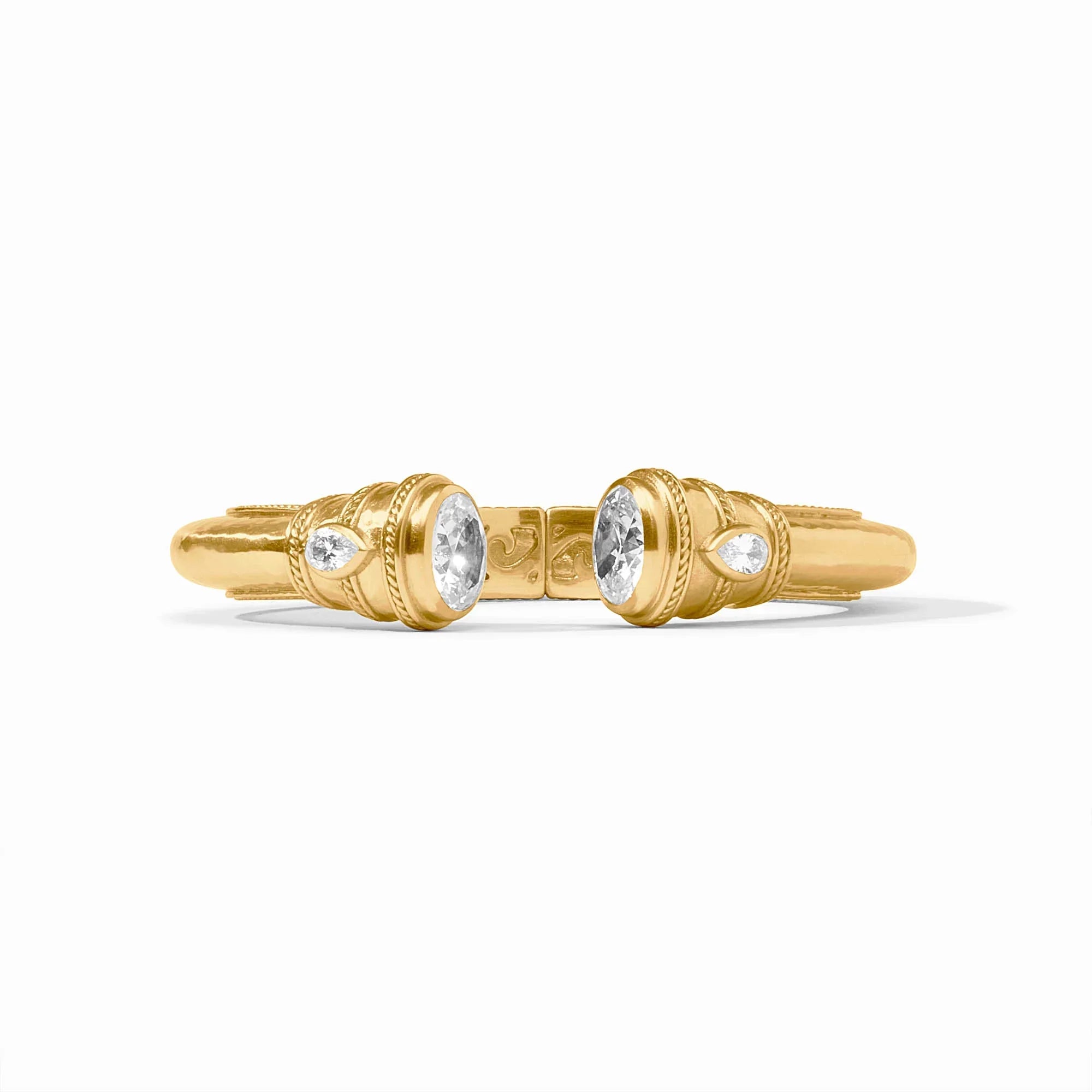 Gold cuff with cubic zirconia accents on a white background