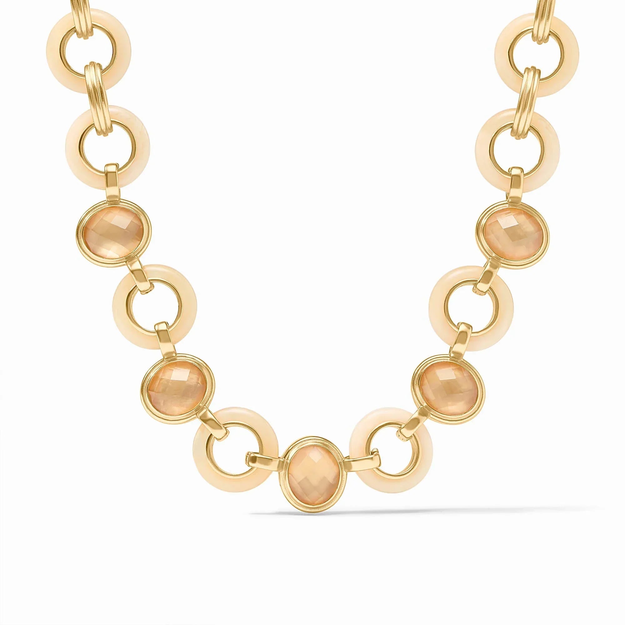 Gold necklace with peach-colored gemstones on a white background