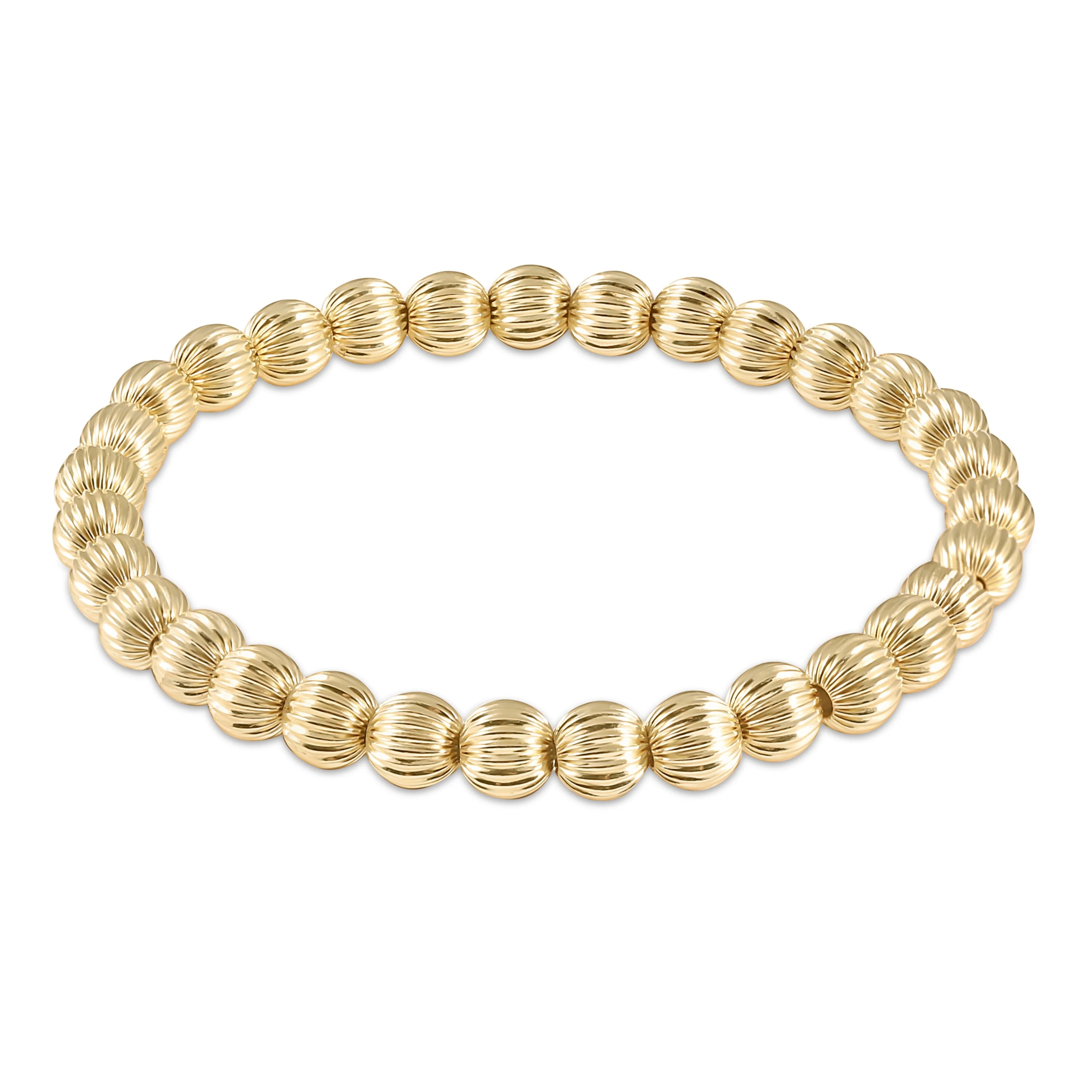 Gold beaded bracelet on a white background