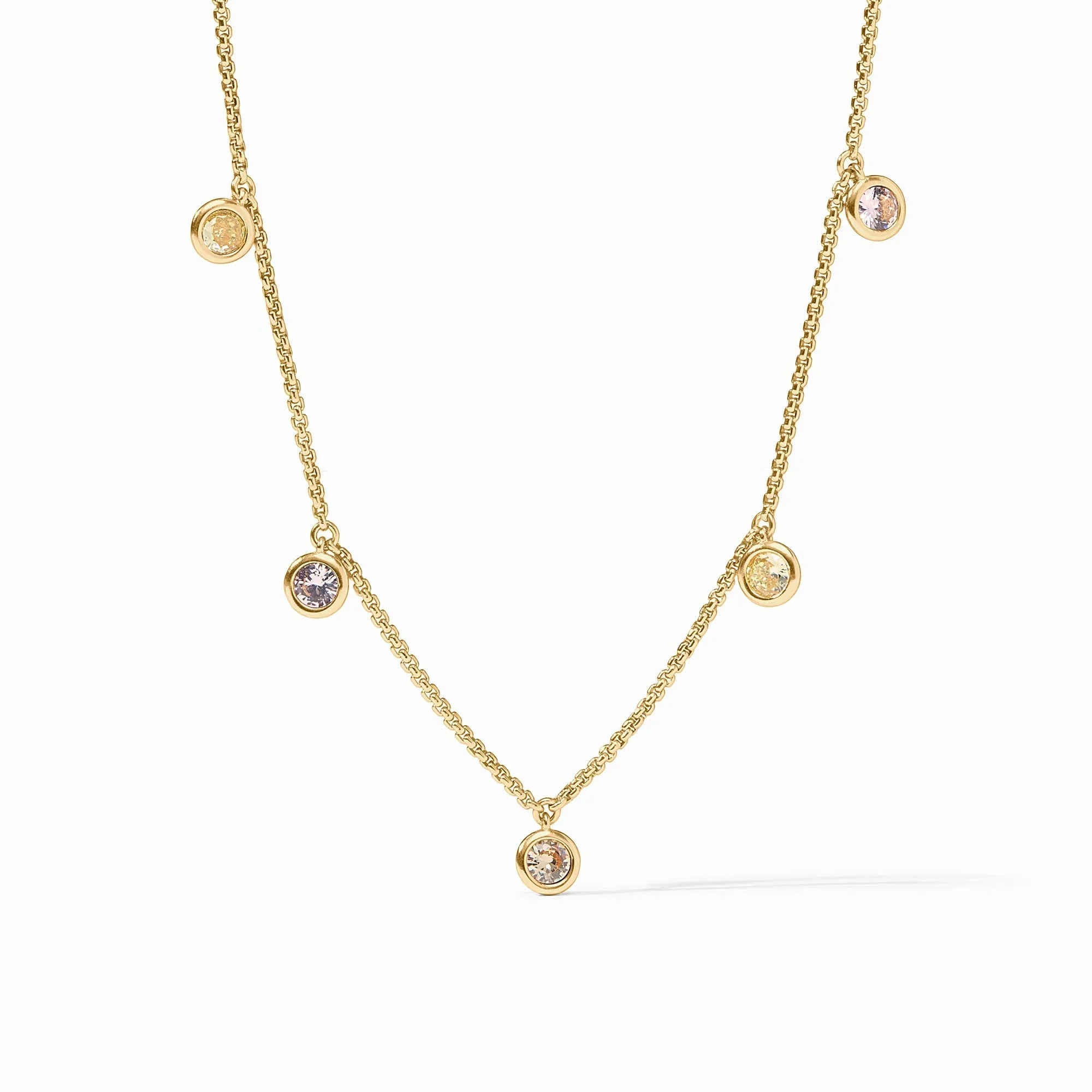 Gold necklace with small round gemstones on a white background