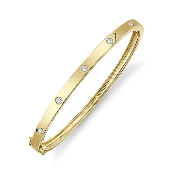 Gold bangle with small diamonds on a white background