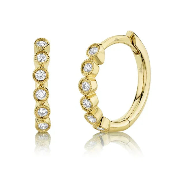 Gold hoop earring with embedded diamonds on a white background