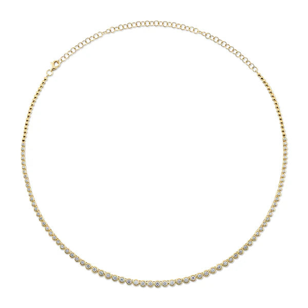 Gold necklace with small round stones on a white background