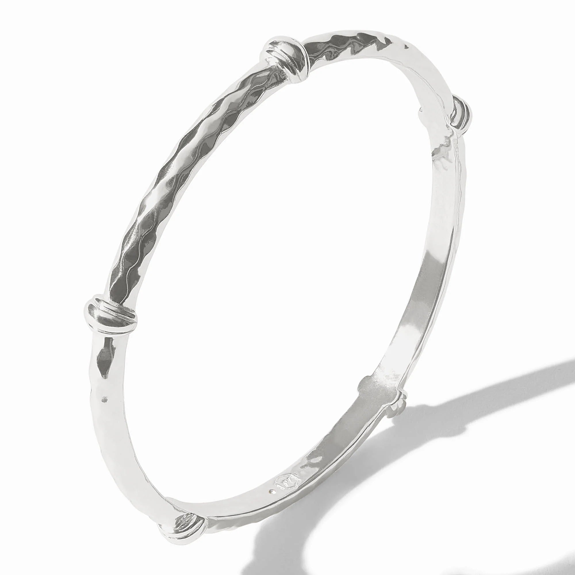 Silver bangle with textured design on a white background