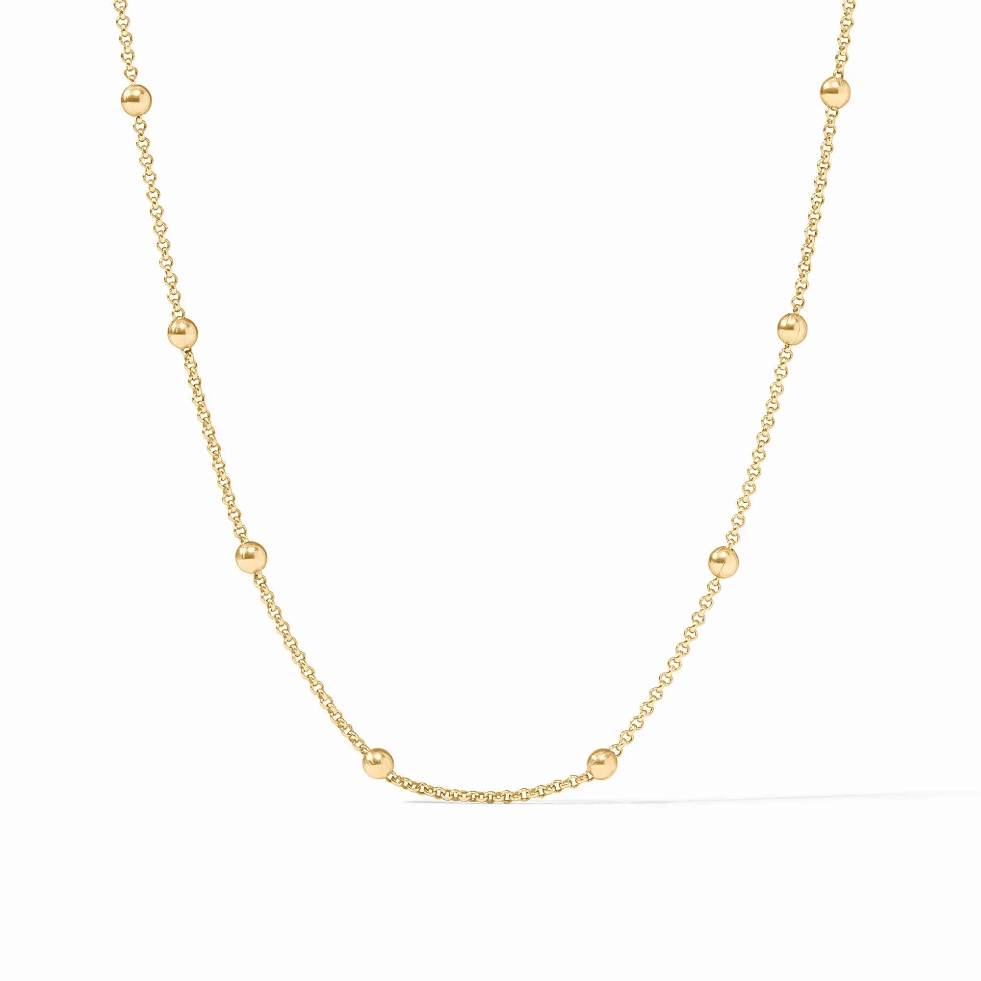 Gold necklace with small beads on a white background