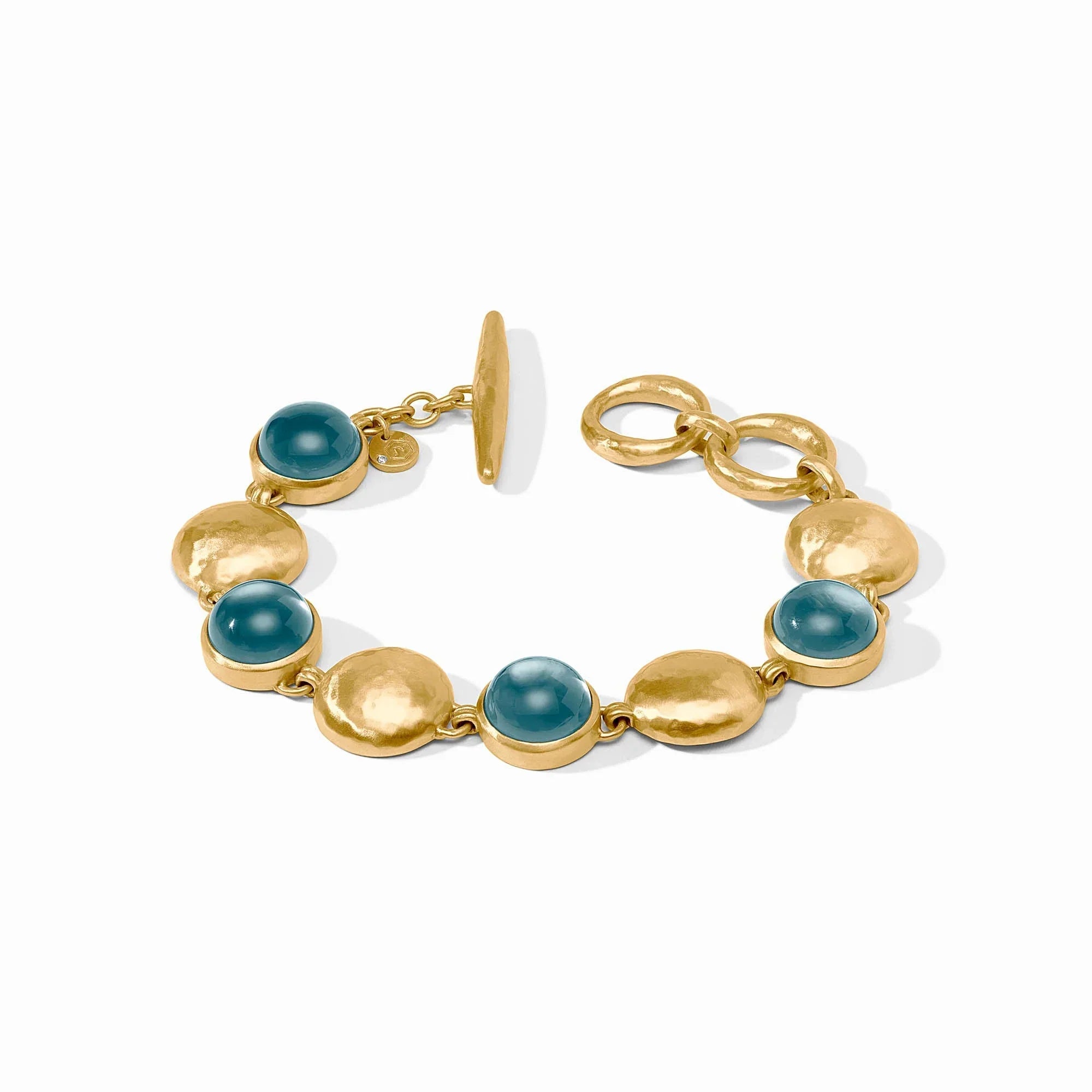 Gold bracelet with blue gemstones on a white background