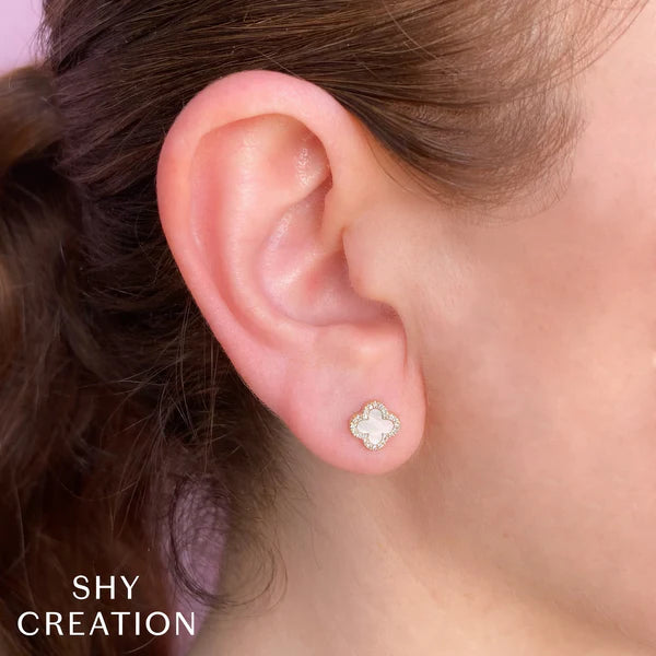 Close-up of an ear wearing a diamond stud earring with 'SHY CREATION' branding.